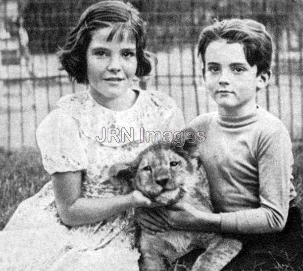 Girl and boy with a lion cub