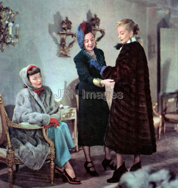 Three ladies trying on new fur coats