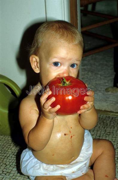 Boy eating tomato