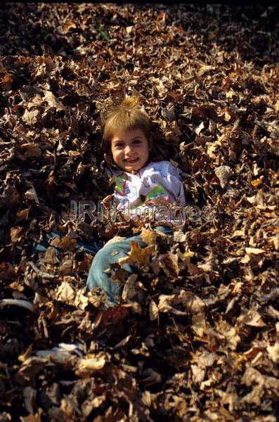 Child playing in leaves